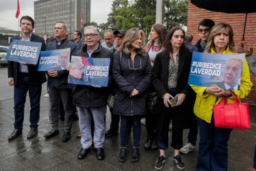Simpatizantes del expresidente colombiano Álvaro Uribe sostienen carteles de apoyo este lunes, frente a los juzgados de Paloquemao en Bogotá (Colombia). 