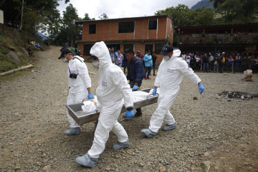Integrantes de la Policía Judicial colombiana trasladando el cuerpo de una persona fallecida, en un operativo militar contra la minería ilegal, en el corregimiento Pichendé a unos 16 km de Cali. 
