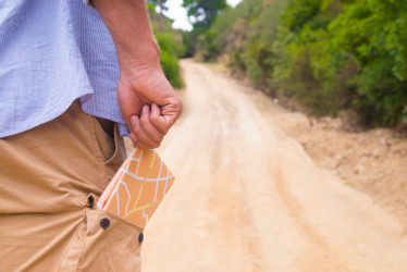Hombre de pie con mapa de viaje en el bolsillo trasero