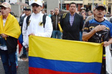 Los asistentes acudieron con banderas de Colombia y con mensajes de apoyo a los uniformados del país. 