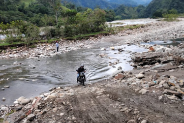 La vía colapsó en abril de este 2025 por una creciente del río Samaná Sur. Maquinaria de Antioquia desvía el caudal antes de reconstruir la carretera.