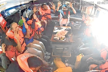 Fotografía facilitada por la Coalición de la Flotilla de la Libertad (FFC), de la tripulación del buque Madleen, con destino a Gaza, sentada en la embarcación, con chalecos salvavidas y las manos en alto, en el Mediterráneo.