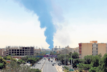 Fotos | EFE | LAPATRIA El humo de una refinería de petróleo se eleva sobre edificios residenciales en el sur de Teherán (Irán). Israel continuó atacando instalaciones relacionadas con el programa nuclear y energéticas. Irán lanzó misiles y drones hacia Israel.