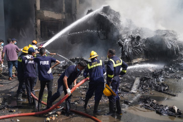 Los bomberos trabajan en el lugar de un accidente aéreo cerca del Aeropuerto Internacional Sardar Vallabhbhai Patel en Ahmedabad, Gujarat,