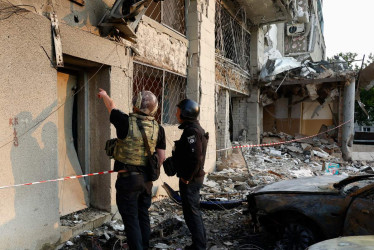  Agentes de la policía ucraniana trabajan en el lugar donde un dron atacó un edificio residencial en Járkov, noreste de Ucrania, el 12 de junio de 2025, en medio de la invasión rusa. 