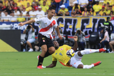 Jhon Durán, de Colombia, disputa un balón con Renzo Garcés, de Perú. La Tricolor es sexta en las eliminatorias, con 21 puntos. En sus últimos cinco partidos ha perdido tres y perdido dos. El martes visita a Argentina.