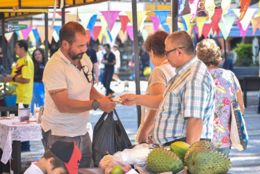 Un campesino vende productos del campo a compradores en Chinchiná.