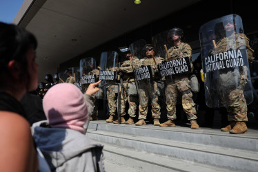 Varios manifestantes se manifiestan en frente de la Guardia Nacional que protege un edificio federal en Los Ángeles, California.