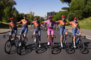Simon Yates con la 'maglia rosa', acompañado con su equipo Visma Lease a Bike.