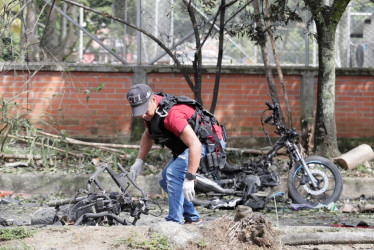 Un perito forense trabaja en los alrededores de la estación de policía del barrio Meléndez donde ocurrió un atentado este martes, al sur de Cali (Colombia).