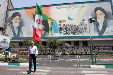 Un hombre iraní pasa junto a una pintura mural del líder supremo de Irán, el ayatolá Ali Khamenei 