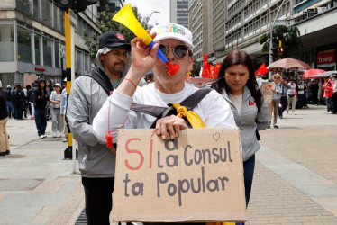 Una mujer sostiene un cartel durante una marcha convocada por las centrales obreras en apoyo a la intención del presidente colombiano, Gustavo Petro