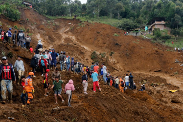 Ciudadanos observan la zona afectada por la avalancha del martes en Bello (Antioquia). 13 personas han fallecido.