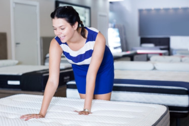 Mujer probando un colchon en una tienda