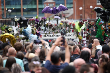  Los fanáticos observan el cortejo fúnebre del músico Ozzy Osbourne mientras pasa por el banco y el puente de Black Sabbath en Birmingham.