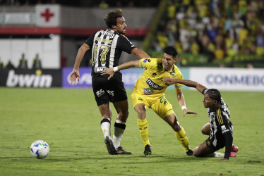 Leonardo Flores, de Bucaramanga, disputa el balón con Ronielson da Silva (der.) e Igor Gomes, de Mineiro. El cuadro brasileño ganó 0-1 en la ciudad bonita.