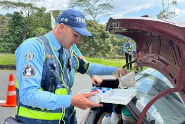 Un agente de tránsito verifica el equipo de seguridad de un vehículo durante un operativo en Manizales.