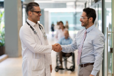 Hombre y un medico se dan la mano en un hospital