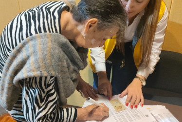 Offir Vélez firma la carta de indemnización como víctima del conflicto armado en Caldas. 