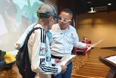 Adit Rafael Romero Polanco, director general de la Unidad de Víctimas, entrega una carta de indemnización a una víctima del conflicto armado en Manizales. 