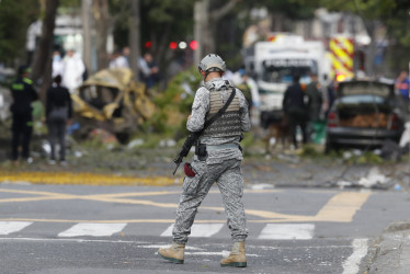 Un integrante de la Fuerza Aérea custodia la zona del atentado tras una explosión en inmediaciones de la Escuela Militar de Aviación Marco Fidel Suárez este jueves, en Cali (Colombia). 