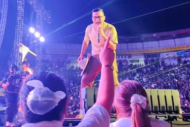 Claudio Orozco, levanta la mano, mientras Yeisón Jiménez le canta durante su concierto en la Plaza de Toros de Manizales. 
