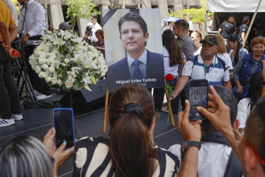 Personas toman fotografías a una imagen del fallecido senador y precandidato de Colombia Miguel Uribe Turbay, durante un homenaje este martes, en Medellín (Colombia)