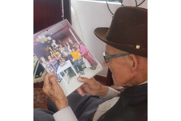 El neirano Luis Evelio Loaiza, de 101 años, contempla una foto de su familia, compuesta por 17 hijos, 37 nietos, 24 bisnietos y 5 tataranietos.