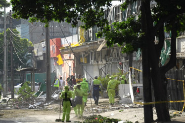 Personal de aseo recoge escombros en una calle cercana a la Escuela Militar de Aviación Marco Fidel Suárez este viernes, en Cali (Colombia).