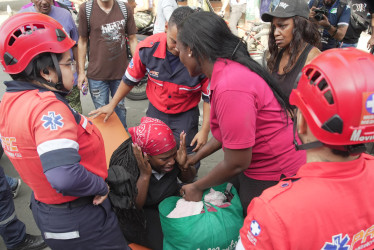 Una mujer es atendida por personal medico tras una explosión en inmediaciones de la Escuela Militar de Aviación Marco Fidel Suárez este jueves, en Cali (Colombia).