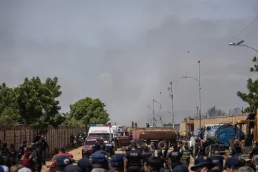 Personas caminan por la zona afectada debido a una explosión de una fábrica de fuegos artificiales este jueves, en San Francisco (Venezuela).