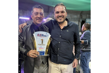 El alcalde de Neira, Jhon Jairo Castaño, posa con el director de la banda del municipio, Holver Mauricio Cardona, con el galardón que acredita a la agrupación como la ganadora del Concurso Departamental de Bandas este 2025 en Caldas.
