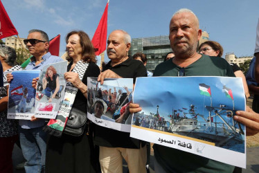 Activistas portan fotografías de dos de los activistas libaneses detenidos, Lina Tabbal y el libanés-brasileño Mohammed Al Kadri, durante una protesta. 