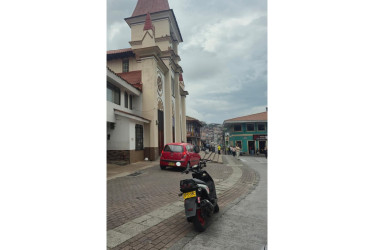 Hay vehículos que se parquean en el atrio de la iglesia de Villamaría.