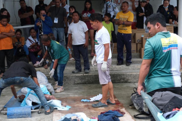 Los ciudadanos observan a las víctimas tras un terremoto en la ciudad de Bogo, isla de Cebú, Filipinas.