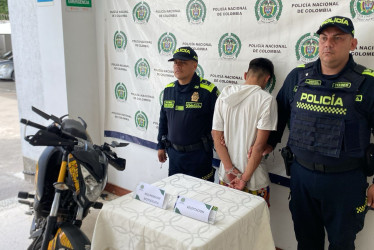  La moto recuperada y la persona que terminó detenida.