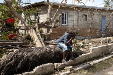Un hombre descansa frente a una casa llena de escombros tras el paso del huracán Melissa este lunes, en Falmouth (Jamaica).