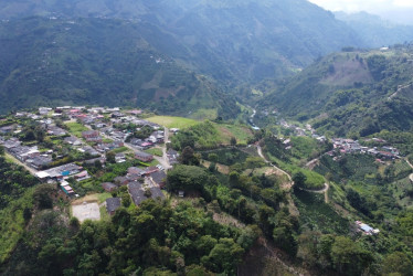 Panorámica aérea que muestra la actual vereda Nuevo Rioclaro (a la izquierda) y el antiguo caserío que afectó la avalancha (a la derecha), junto al río Chinchiná.