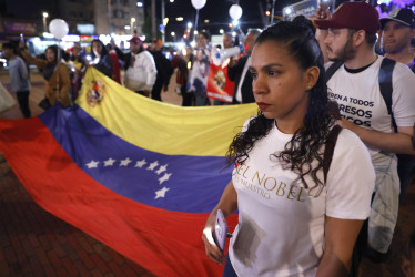 Personas participan en la marcha "por la paz y la libertad" en Venezuela, en conmemoración al Nobel de la Paz que será entregado el 10 de diciembre a la líder antichavista María Corina Machado, este sábado, en Bogotá 