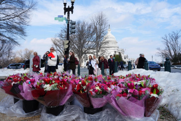 Personas caminan frente a ramos de flores colombianas este miércoles, en Washington (EE.UU.).