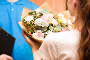 Mujer recibiendo un domicilio de flores