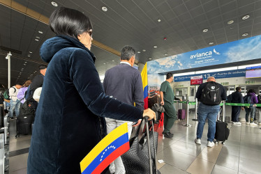 Personas esperan para abordar el vuelo Bogotá - Caracas de la aerolínea Avianca este jueves, en el aeropuerto El Dorado en Bogotá (Colombia).