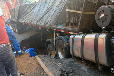 La vía está cerrada mientras las autoridades atienden el accidente. Una tractomula hundió una calle de Manizales y terminó enterrada. Estas son las imágenes.