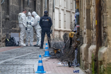 Agentes de la Policía Nacional junto al edificio de la localidad de Miranda de Ebro (España) incendiado este martes, en el que han muerto tres mujeres.