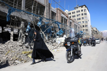 Una mujer iraní camina junto a un edificio dañado alrededor de la plaza Ferdowsi después de un ataque aéreo en el centro de Teherán (Irán) este 3 de marzo.