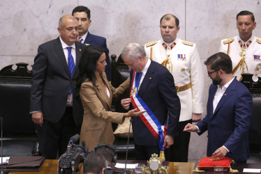 José Antonio Kast (centro) recibió la imposición de la banda presidencial de la nueva presidenta de la cámara alta, la conservadora Paulina Núñez, ante la mirada del saliente mandatario chileno, Gabriel Boric.