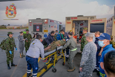 Integrantes de organismos de rescate trasladan a un herido de un accidente aéreo este lunes, en el Comando Aéreo de Transporte Militar (Catam) en Bogotá. 