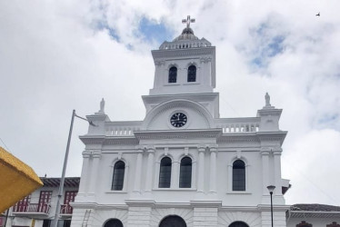 El imponente color blanco del templo San Juan Bautista de Neira contrasta con las nubes.
