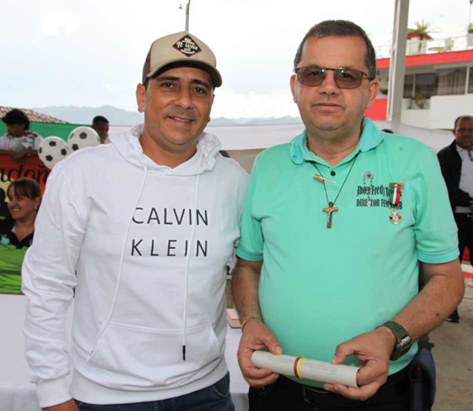 Hernán Felipe Herrera, director de Deportes y Cultura de Neira, entrega reconocimiento a Jhon Freddy Tobón Jaramillo, director de la revista Golazo.