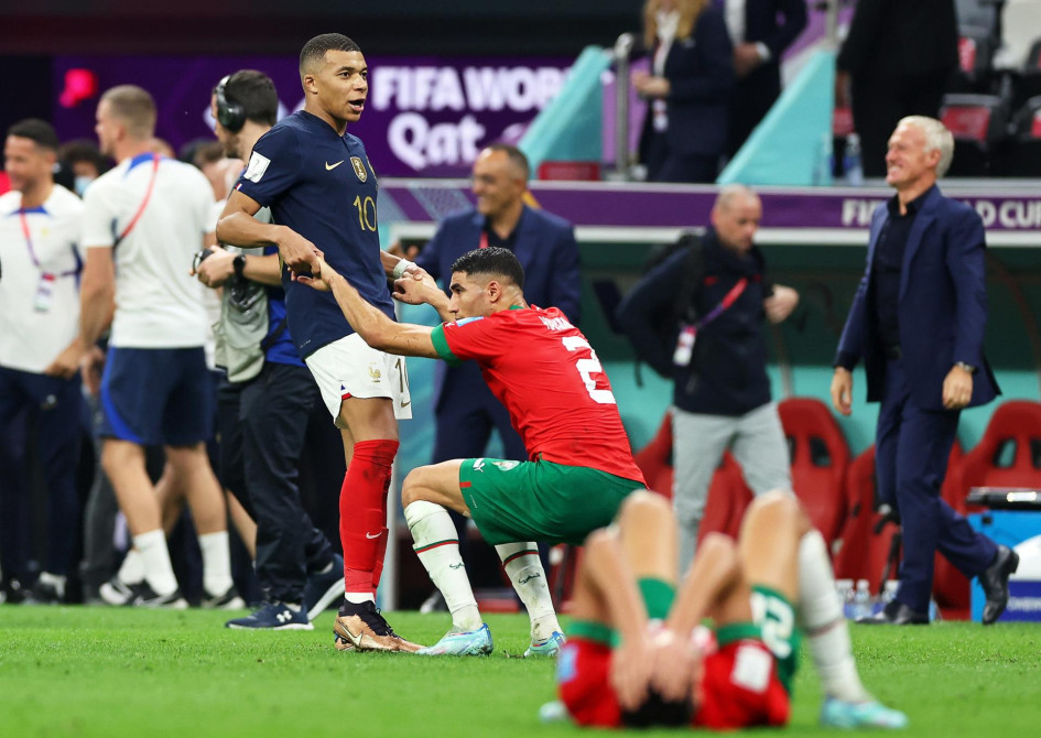 Kylian Mbappé (izquierda) levanta a su amigo marroquí Achraf Hakimi, derrumbado tras perder ante Francia la semifinal de la Copa del Mundo.